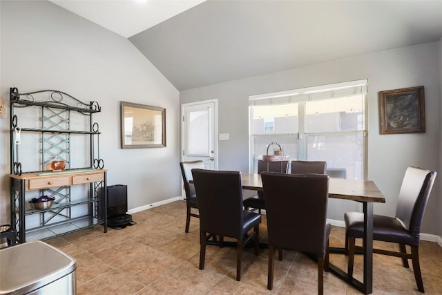 dining space featuring vaulted ceiling and baseboards