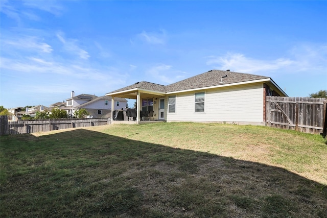 rear view of property featuring a yard