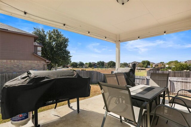 view of patio / terrace with outdoor dining space, a grill, and fence