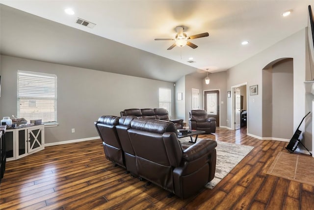 living area featuring ceiling fan, arched walkways, dark wood-type flooring, baseboards, and recessed lighting