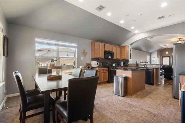 kitchen with black microwave, range with gas stovetop, dishwashing machine, vaulted ceiling, and a center island