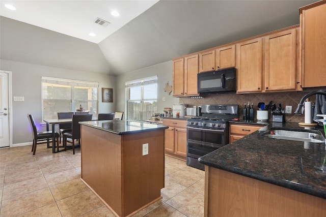 kitchen featuring a kitchen island, dark stone counters, vaulted ceiling, sink, and stainless steel gas range