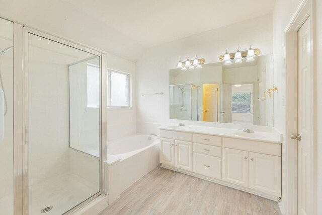 bathroom with a healthy amount of sunlight, vanity, wood-type flooring, and plus walk in shower