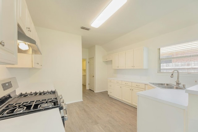 kitchen with white cabinets, sink, light hardwood / wood-style flooring, and gas range gas stove