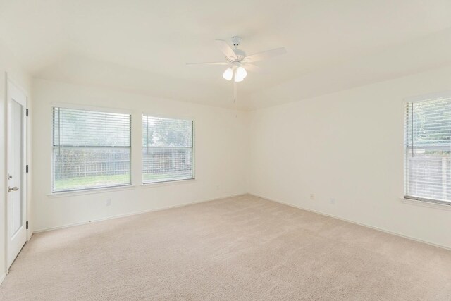 empty room featuring light carpet, ceiling fan, and a wealth of natural light