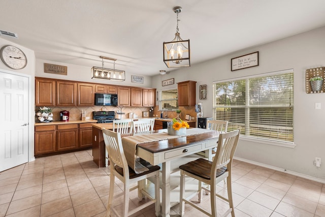 tiled dining space featuring a chandelier