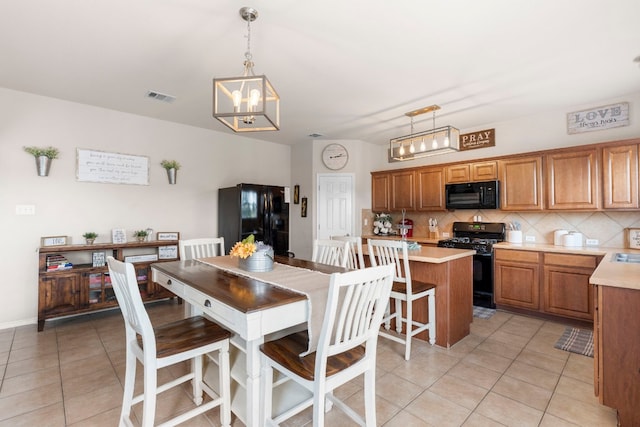 dining area with light tile patterned flooring and a notable chandelier