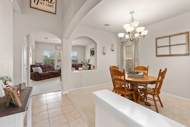 carpeted dining space with an inviting chandelier