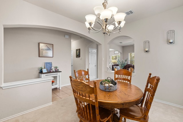 carpeted dining area featuring an inviting chandelier