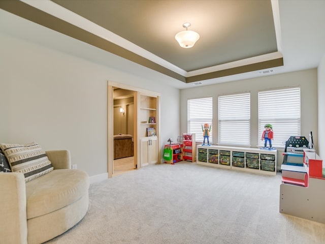 playroom with carpet flooring and a raised ceiling