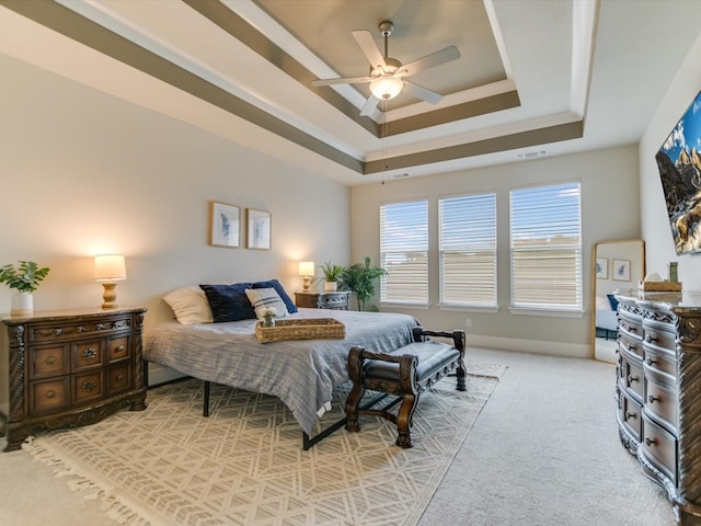 bedroom featuring a tray ceiling, ceiling fan, and light colored carpet