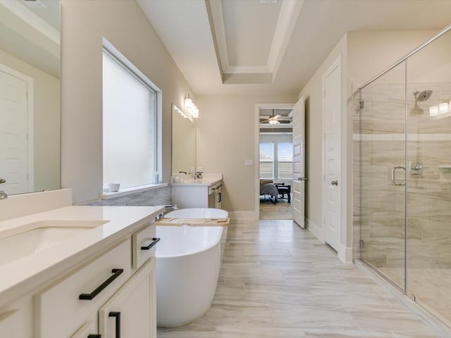 bathroom featuring vanity, ceiling fan, independent shower and bath, and a tray ceiling