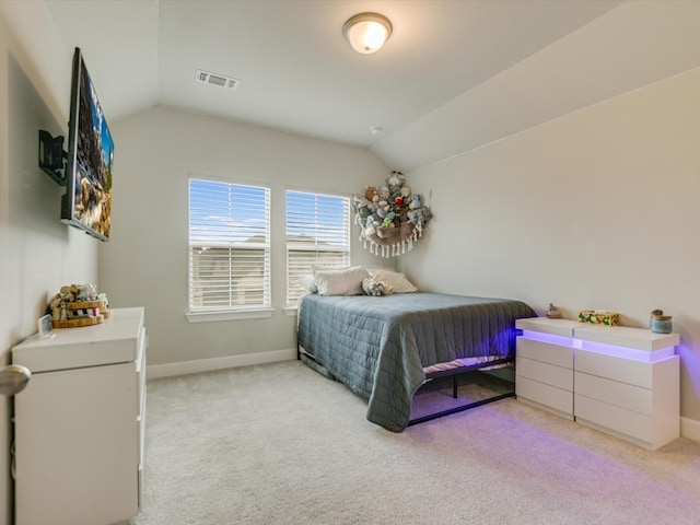 bedroom with light colored carpet and lofted ceiling