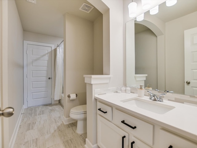 bathroom with vanity, toilet, and walk in shower