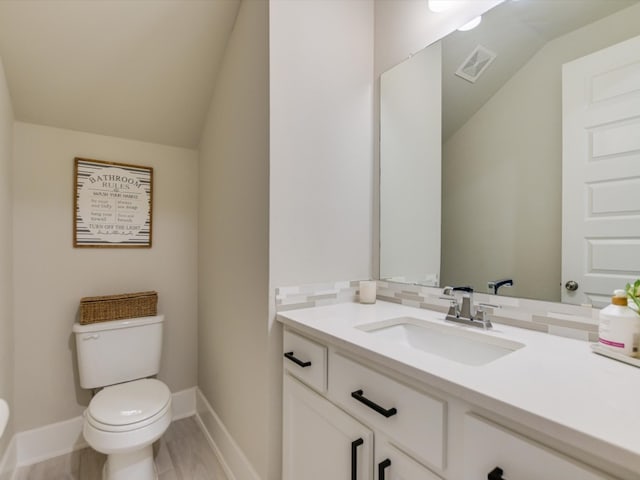 bathroom with vanity, backsplash, vaulted ceiling, toilet, and wood-type flooring