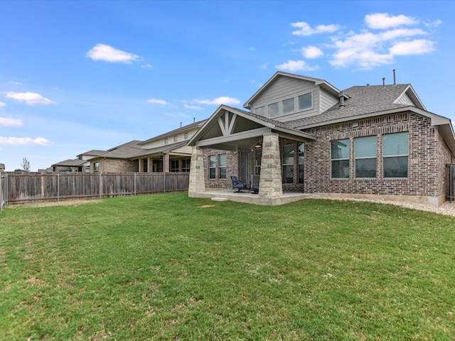 back of property with a lawn and a patio area