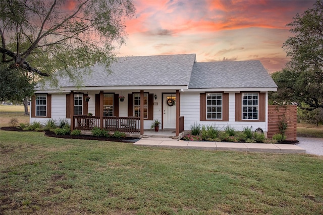 single story home with covered porch and a yard