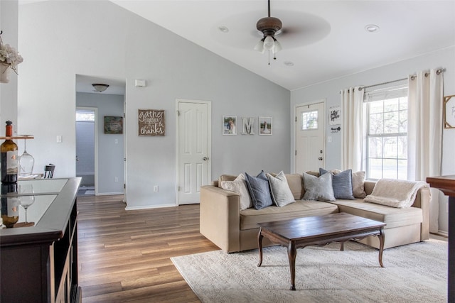 living room with ceiling fan, dark hardwood / wood-style flooring, and high vaulted ceiling