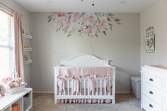 bedroom with a nursery area and light colored carpet