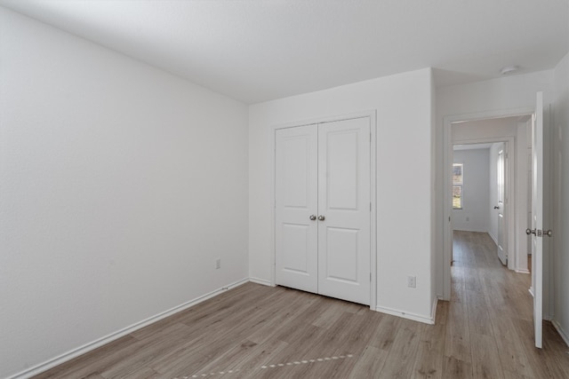 unfurnished bedroom featuring light wood-type flooring and a closet