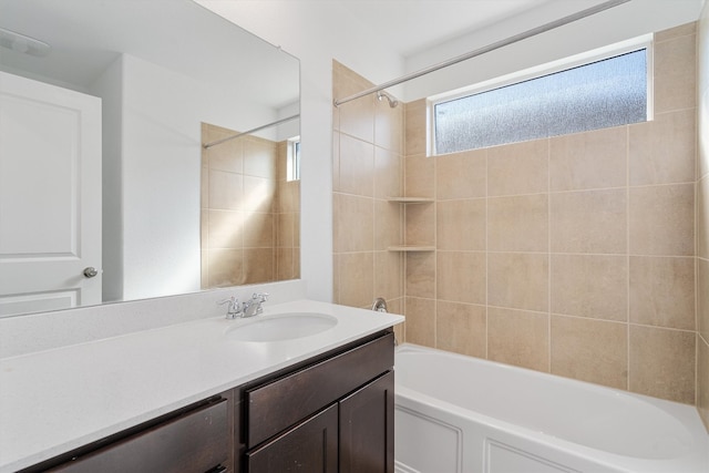 bathroom featuring tiled shower / bath and vanity