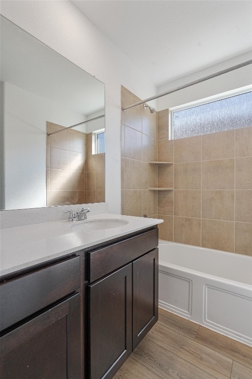 bathroom featuring tiled shower / bath, vanity, and hardwood / wood-style flooring