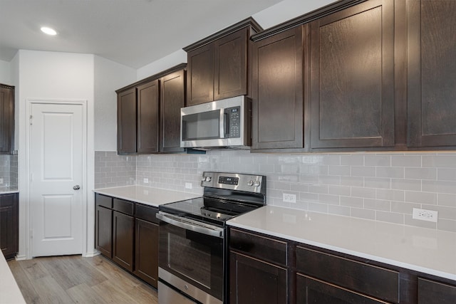 kitchen with backsplash, light hardwood / wood-style floors, dark brown cabinetry, and stainless steel appliances