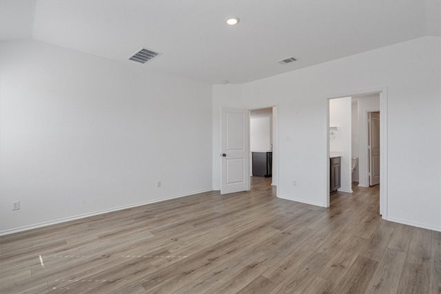 empty room featuring light hardwood / wood-style flooring and lofted ceiling