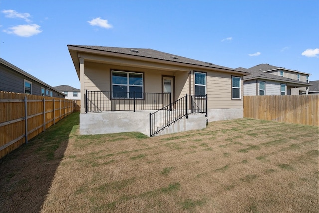 rear view of house featuring a yard