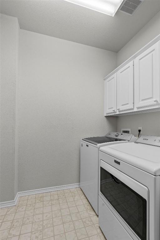 laundry area with cabinets and washing machine and clothes dryer