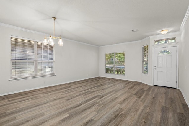 foyer entrance with a chandelier, ornamental molding, and hardwood / wood-style flooring