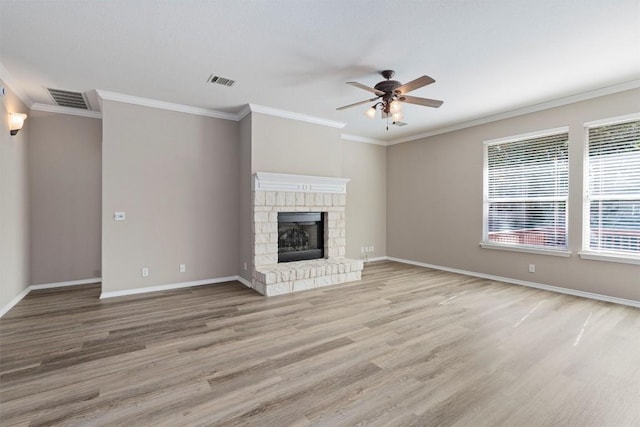 unfurnished living room with ceiling fan, crown molding, a fireplace, and light hardwood / wood-style flooring