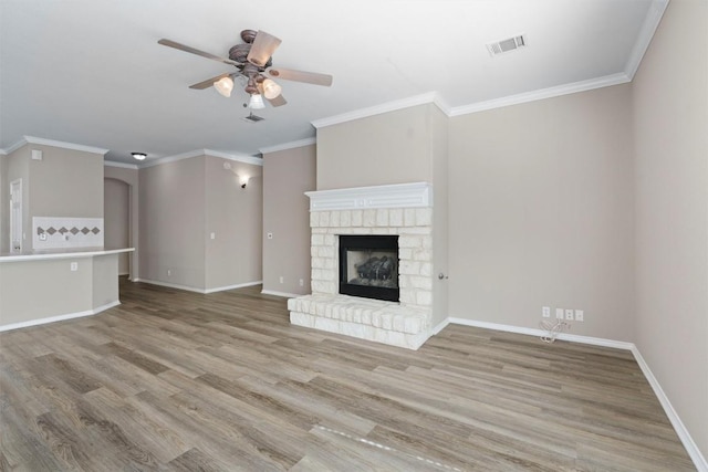 unfurnished living room with ceiling fan, crown molding, and light wood-type flooring