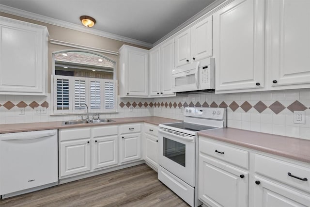 kitchen with white cabinets, white appliances, and sink