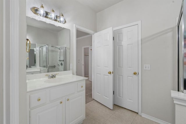 bathroom with tile patterned flooring, vanity, and walk in shower