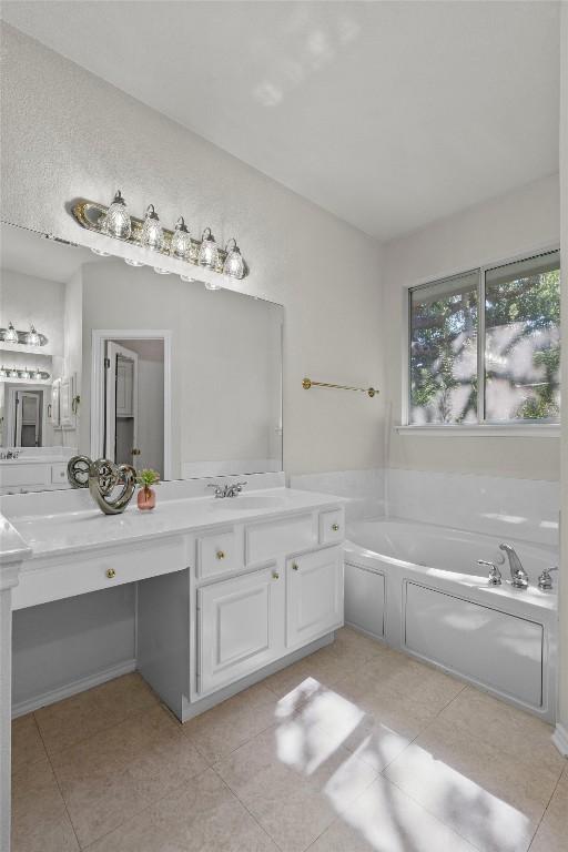 bathroom featuring tile patterned flooring, vanity, and a tub