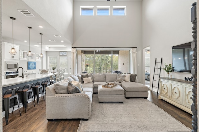 living room with a high ceiling and dark wood-type flooring