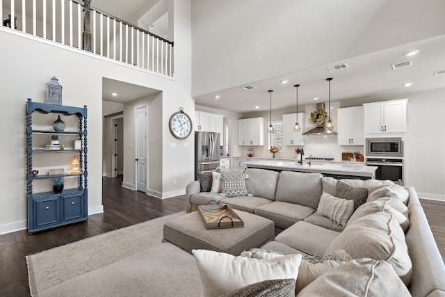 living room with dark wood-type flooring and a high ceiling