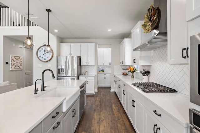 kitchen with white cabinets, decorative light fixtures, sink, and appliances with stainless steel finishes