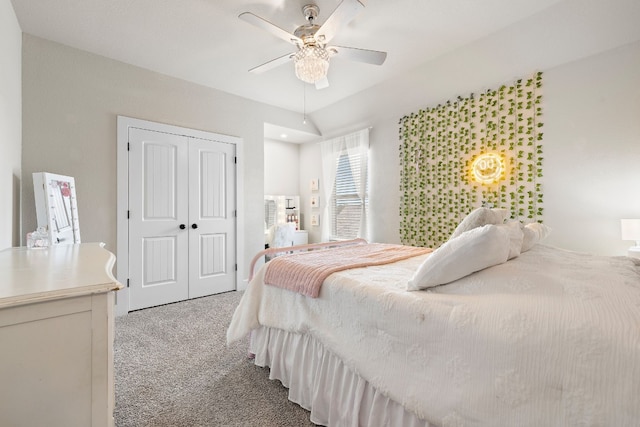 carpeted bedroom with ceiling fan, lofted ceiling, and a closet