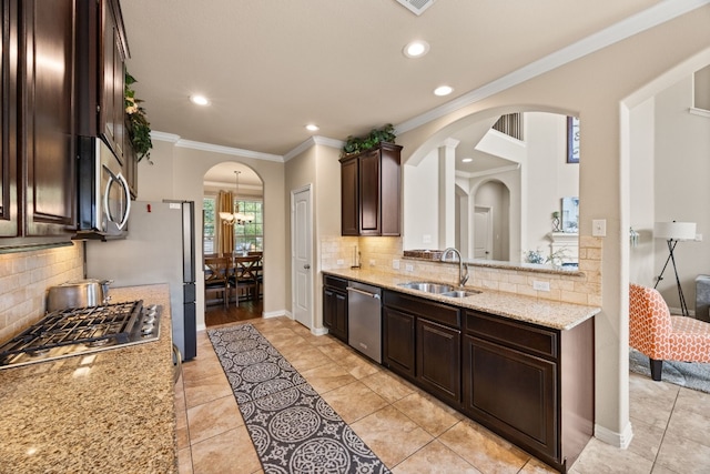 kitchen featuring tasteful backsplash, crown molding, stainless steel appliances, light stone countertops, and sink