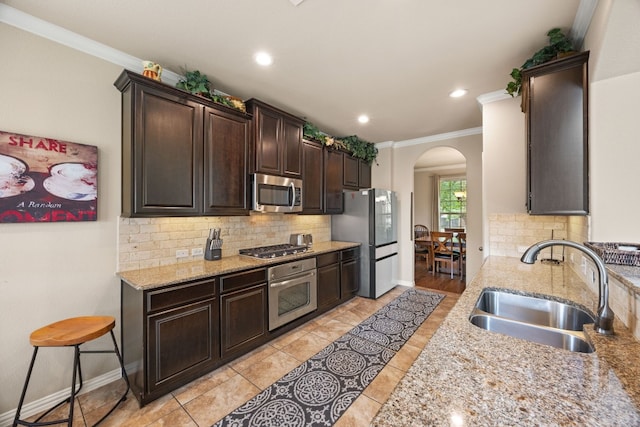 kitchen with crown molding, sink, appliances with stainless steel finishes, and tasteful backsplash