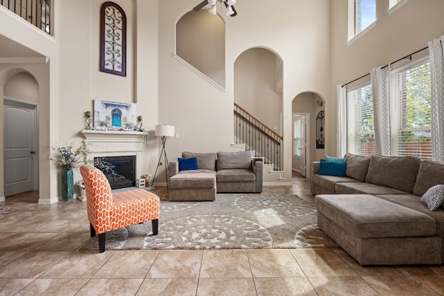 living room featuring ceiling fan and a high ceiling