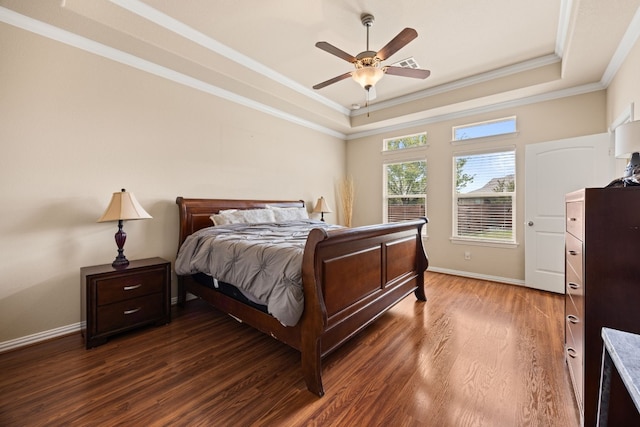 bedroom with dark hardwood / wood-style flooring, crown molding, ceiling fan, and a raised ceiling