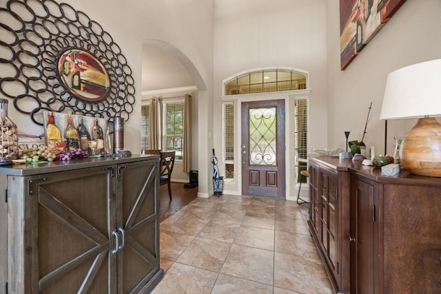 foyer entrance featuring light tile patterned flooring and ornamental molding