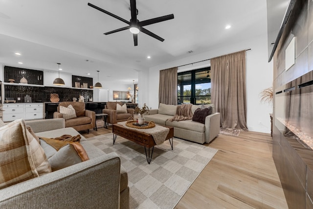 living room with light wood-type flooring and ceiling fan