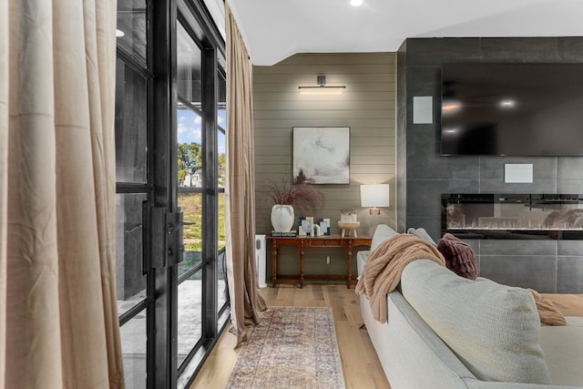 living room with wooden walls and light hardwood / wood-style flooring