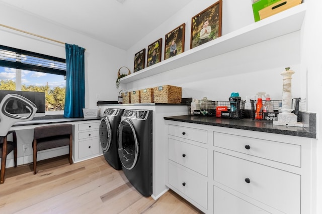 laundry area with washing machine and clothes dryer and light hardwood / wood-style flooring