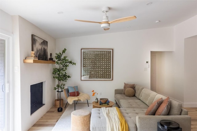 living room with light hardwood / wood-style flooring and ceiling fan