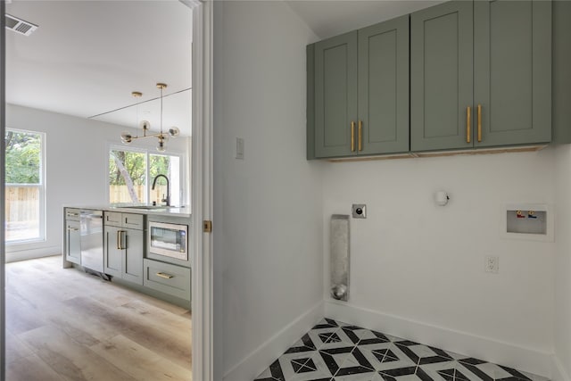 clothes washing area featuring hookup for an electric dryer, cabinets, a wealth of natural light, and washer hookup